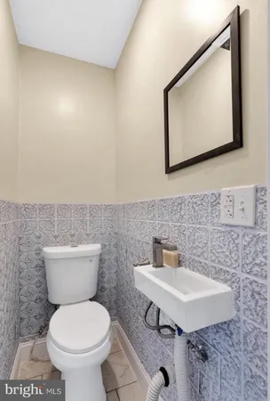 a bathroom with a toilet a sink and mirror