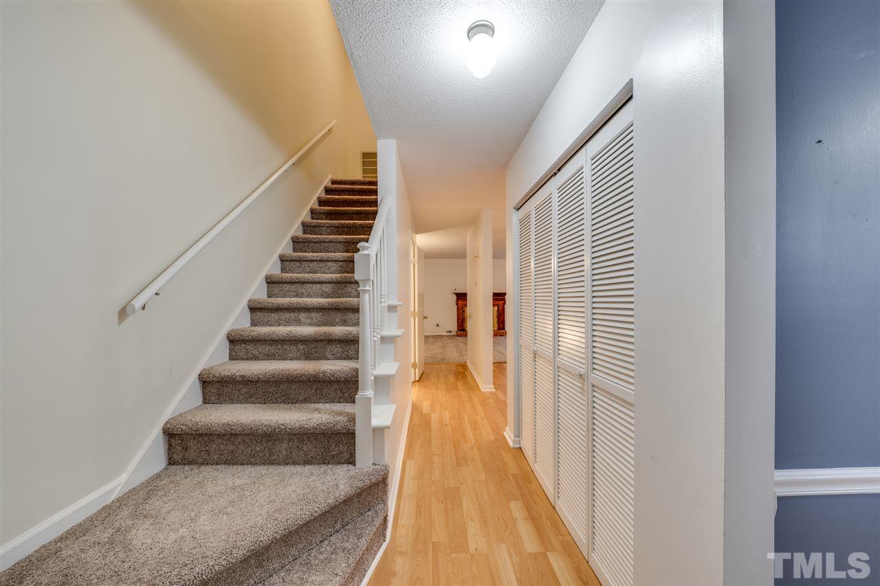 5757 3 Oaks Drive Raleigh, NC 27612 - Photo 3 of 20 a view of a hallway with wooden floor and staircase