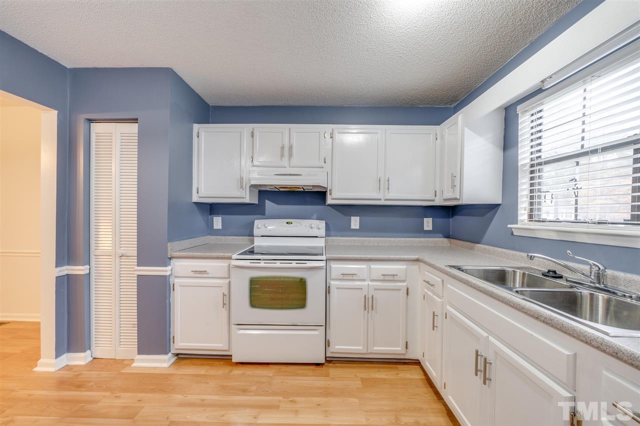 5757 3 Oaks Drive Raleigh, NC 27612 - Photo 4 of 20 a kitchen with a sink a stove and cabinets