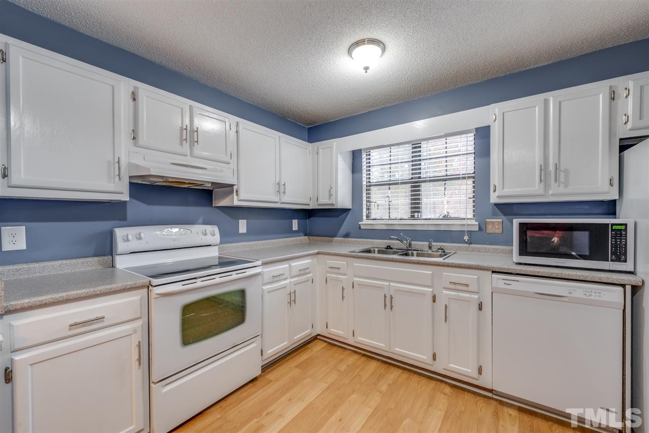 5757 3 Oaks Drive Raleigh, NC 27612 - Photo 6 of 20 a kitchen with granite countertop white cabinets and white appliances