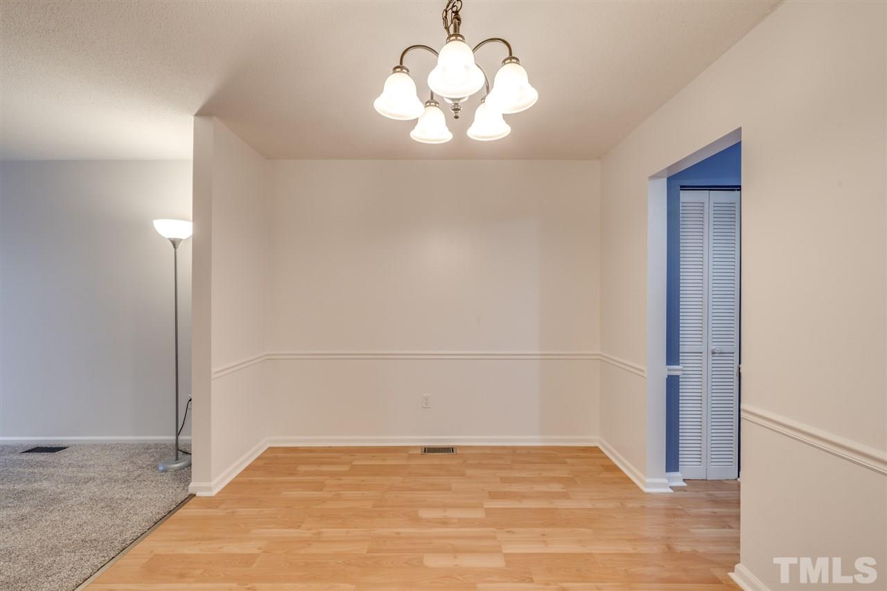 5757 3 Oaks Drive Raleigh, NC 27612 - Photo 8 of 20 a view of an empty room with wooden floor and a window