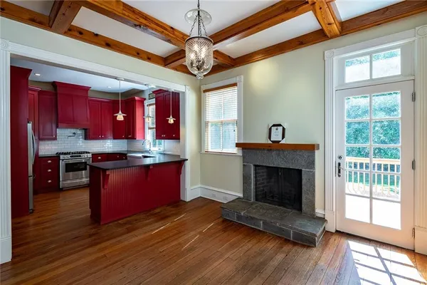 an empty room with wooden floor fireplace and staircase