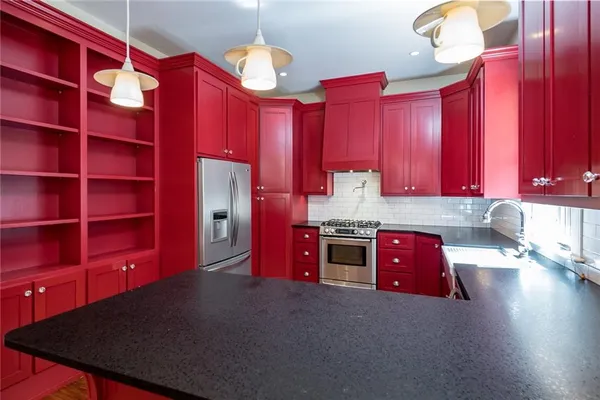 an empty room with wooden floor fireplace and staircase