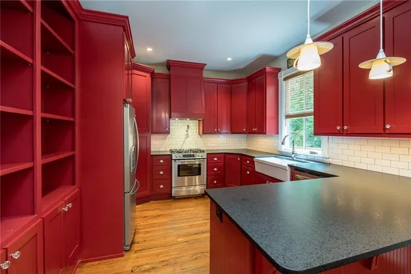 an empty room with wooden floor closet and windows