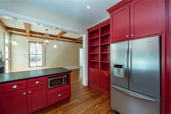 an empty room with wooden floor chandelier fan and windows