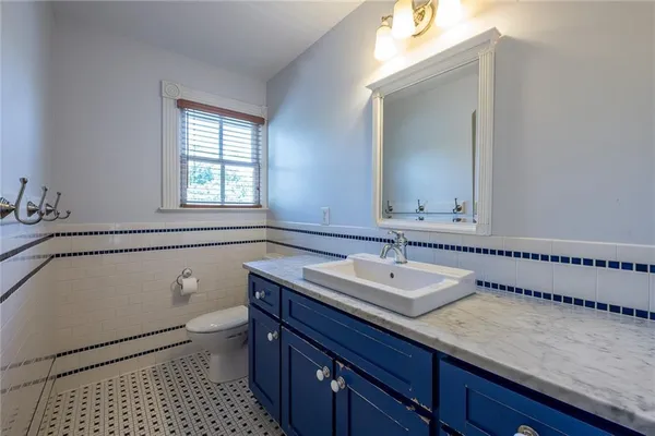 an empty room with wooden floor fireplace and windows