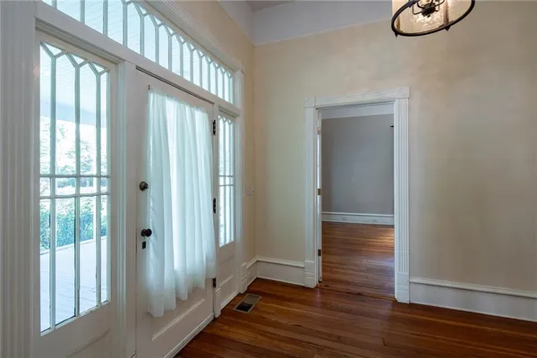a view of empty room with wooden floor