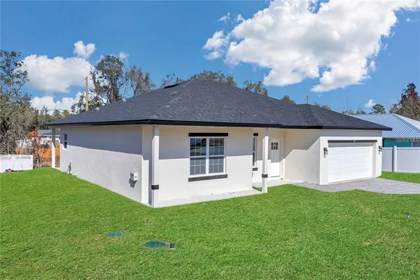 a front view of a house with a garden and yard