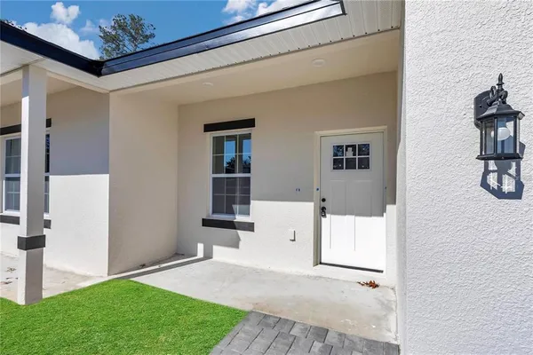 a kitchen with stainless steel appliances granite countertop a sink a stove a refrigerator cabinets and a window