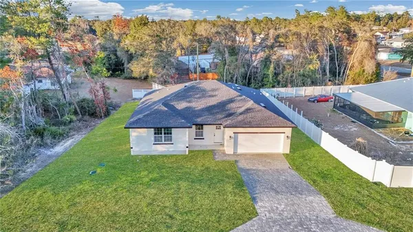 a aerial view of a house with a yard and trees