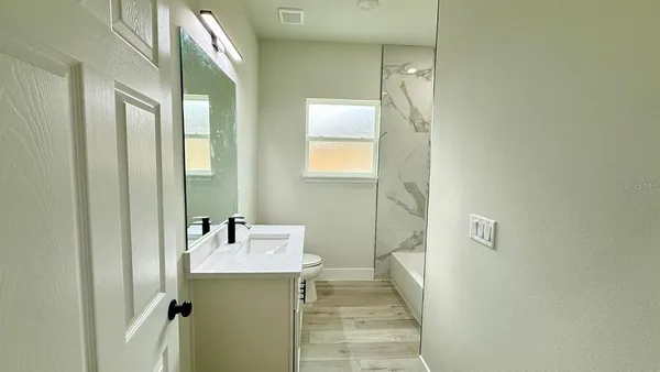 a spacious bathroom with a double vanity sink mirror and toilet