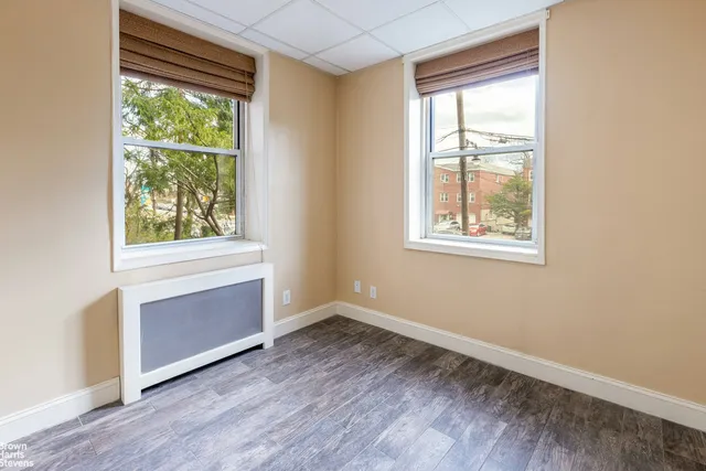 an empty room with a fireplace and windows