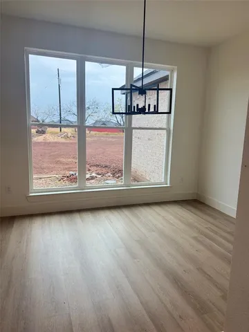 a view of a room with wooden floor stainless steel appliances