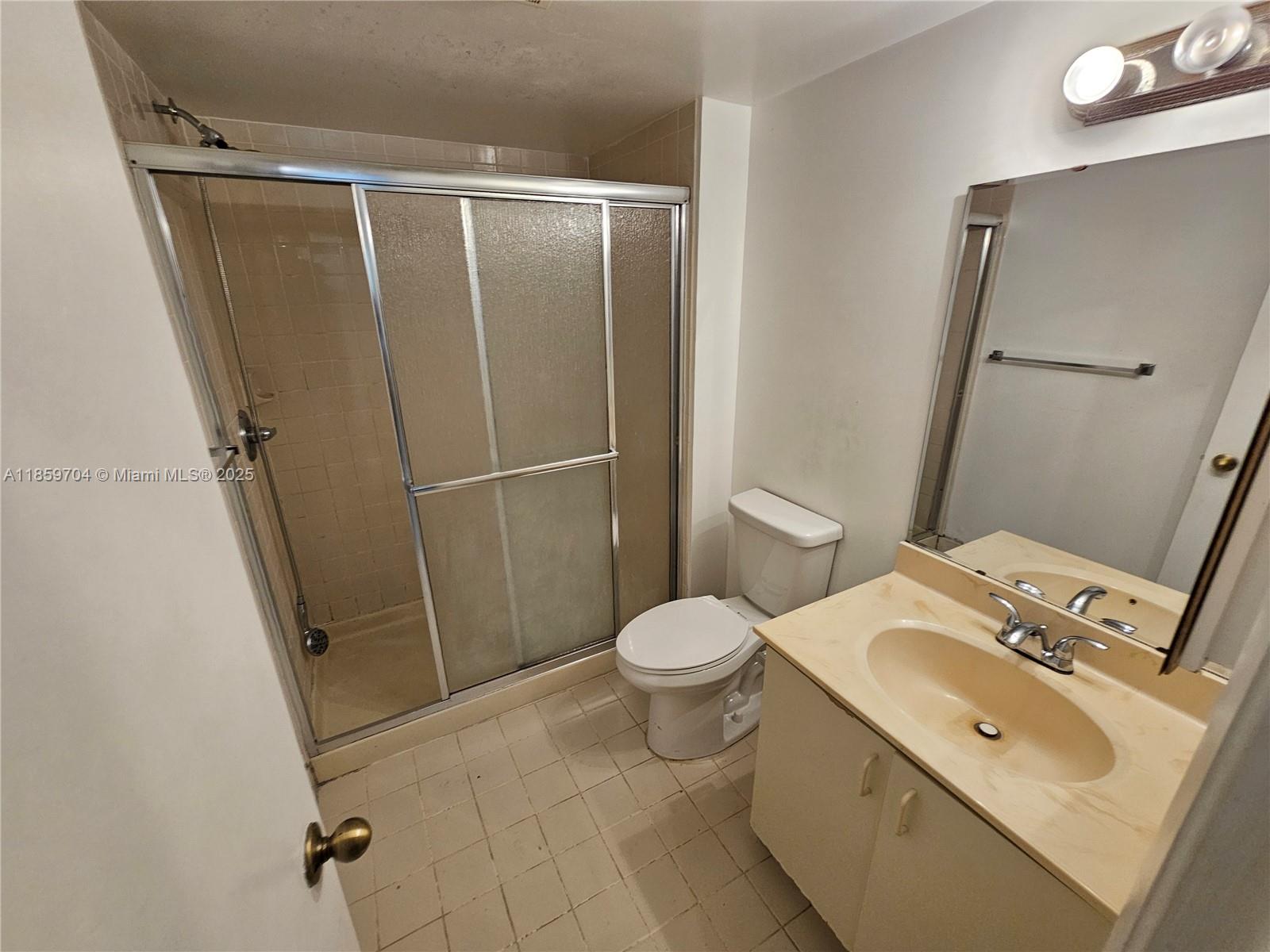 8701 Wiles Road, Unit 305 Coral Springs, FL 33067 - Photo 13 of 17 a bathroom with a sink toilet and shower