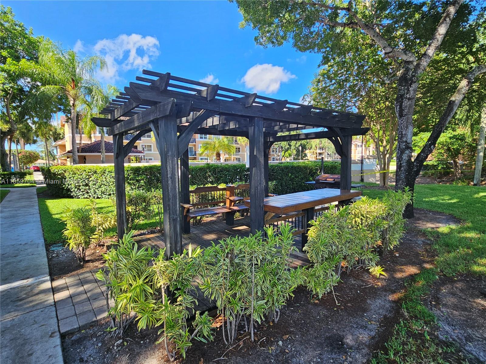 8701 Wiles Road, Unit 305 Coral Springs, FL 33067 - Photo 17 of 17 a view of a chairs and table in the garden
