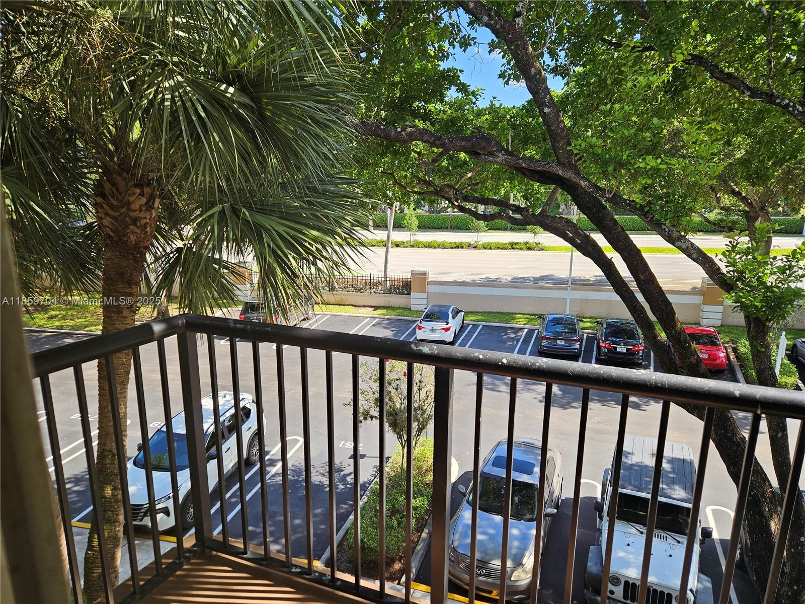 8701 Wiles Road, Unit 305 Coral Springs, FL 33067 - Photo 2 of 17 a view of balcony with wooden floor and fence