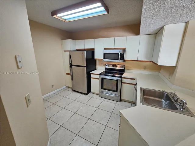 a kitchen with stainless steel appliances a refrigerator and a sink