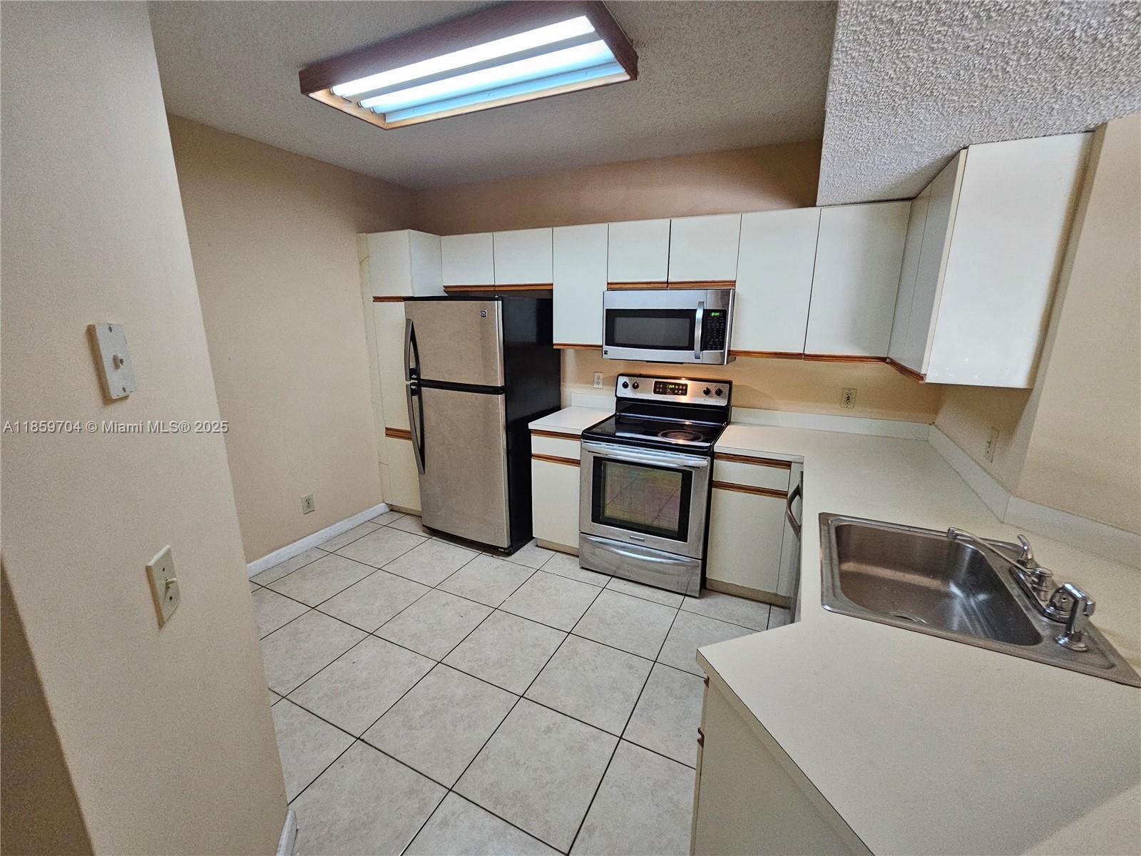 8701 Wiles Road, Unit 305 Coral Springs, FL 33067 - Photo 3 of 17 a kitchen with stainless steel appliances a refrigerator and a sink
