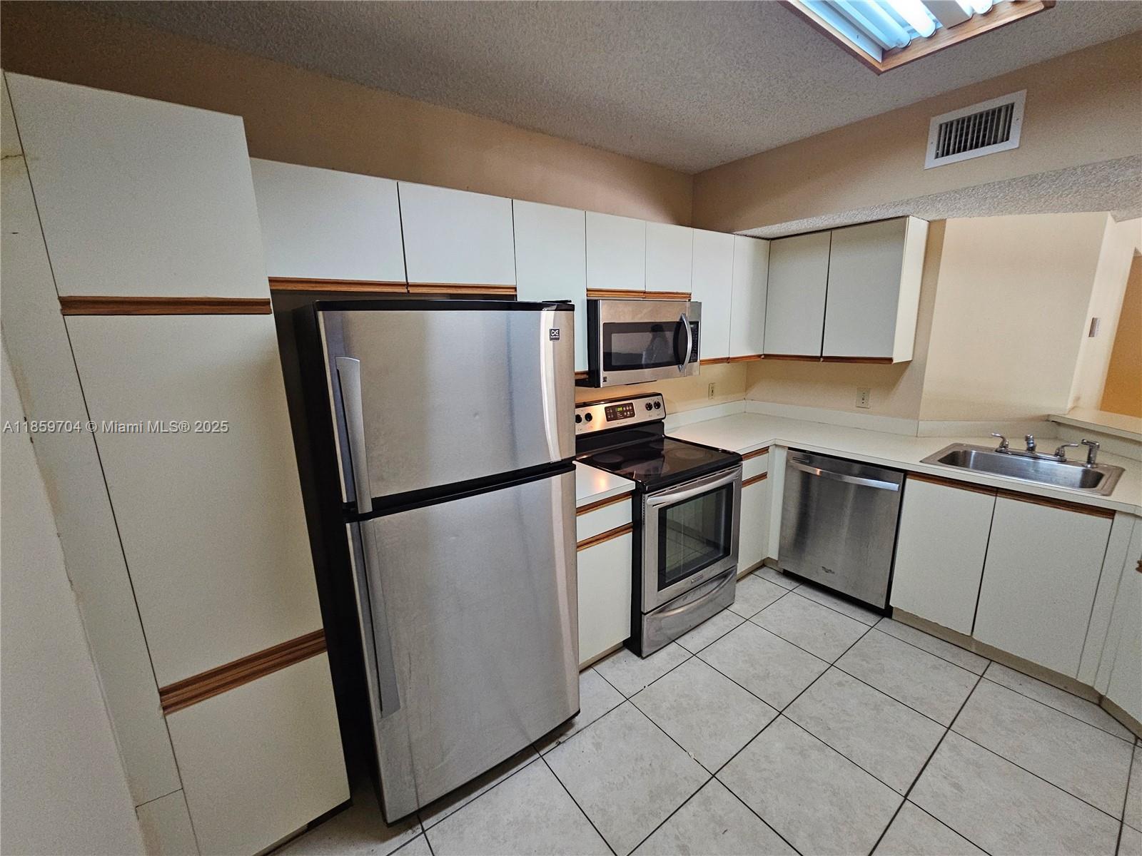 8701 Wiles Road, Unit 305 Coral Springs, FL 33067 - Photo 4 of 17 a kitchen with a refrigerator sink and microwave