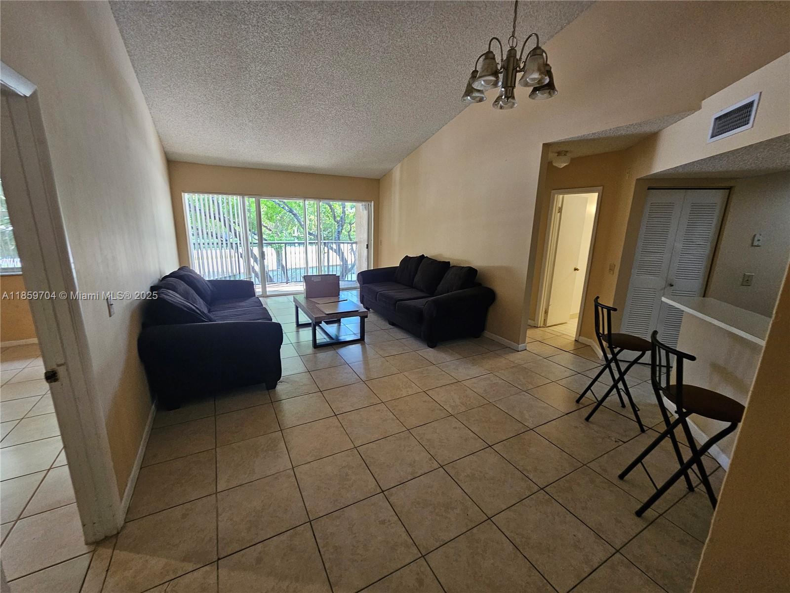 8701 Wiles Road, Unit 305 Coral Springs, FL 33067 - Photo 7 of 17 a living room with furniture and a window