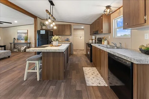 a kitchen with kitchen island granite countertop a sink stove and wooden floor