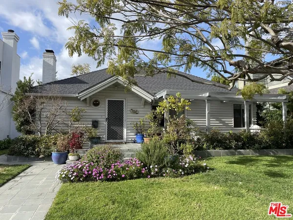 a front view of house with a garden