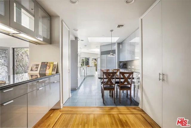 a dining room with stainless steel appliances kitchen island granite countertop a dining table chairs and granite counter tops