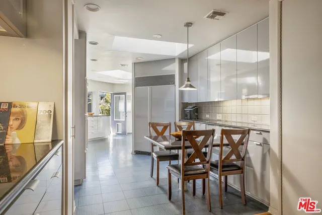 a kitchen with granite countertop a table chairs and a refrigerator