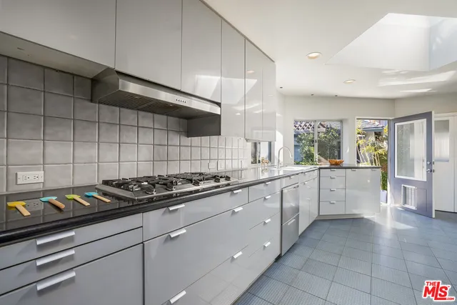 a large kitchen with stainless steel appliances lots of counter space and a sink