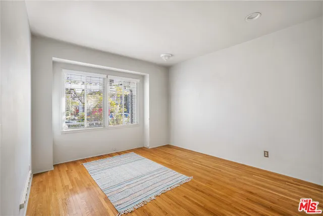 a view of a room with wooden floor and window