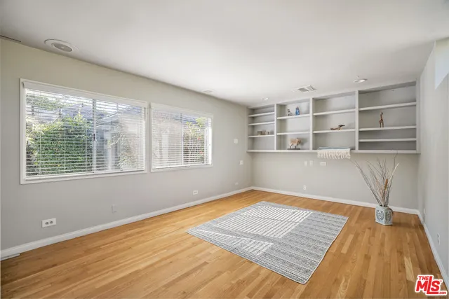 a view of a room with wooden floor and entryway