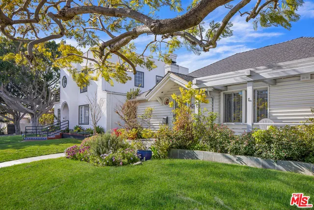 a front view of a house with a garden and plants