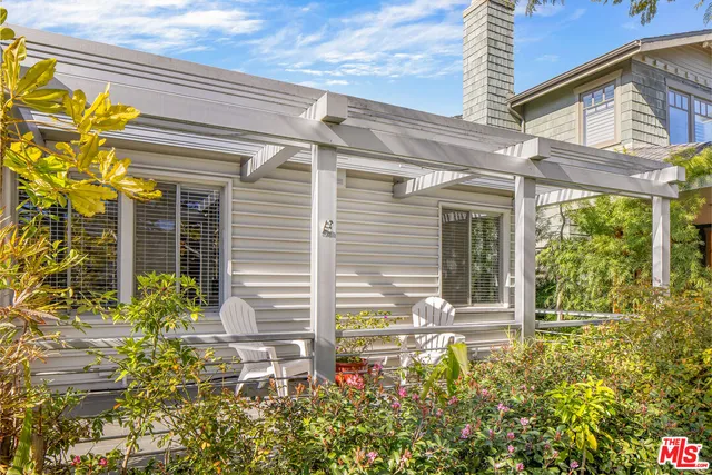 a view of yellow house with a flower garden