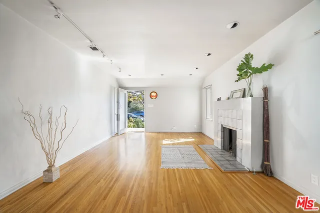 a view of a hallway with wooden floor and a fireplace