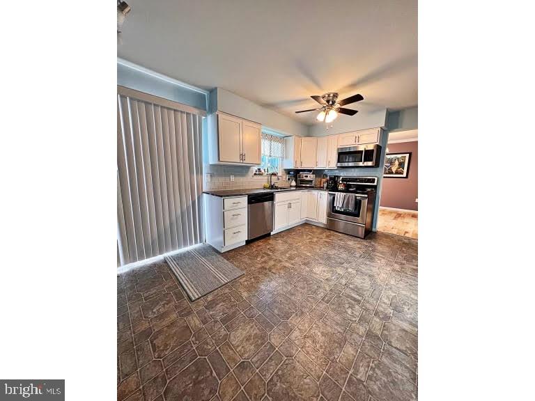 402 Pheasant Circle Bear, DE 19701 - Photo 9 of 17 a open kitchen with kitchen island a sink stainless steel appliances and cabinets