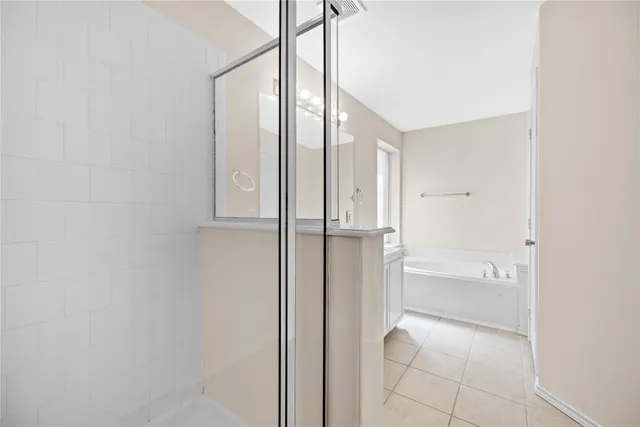 a bathroom with a glass shower door and a bathtub