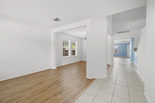 a view of a hallway with wooden floor and a bathroom