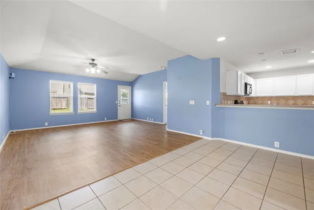 a view of an empty room with window and wooden floor