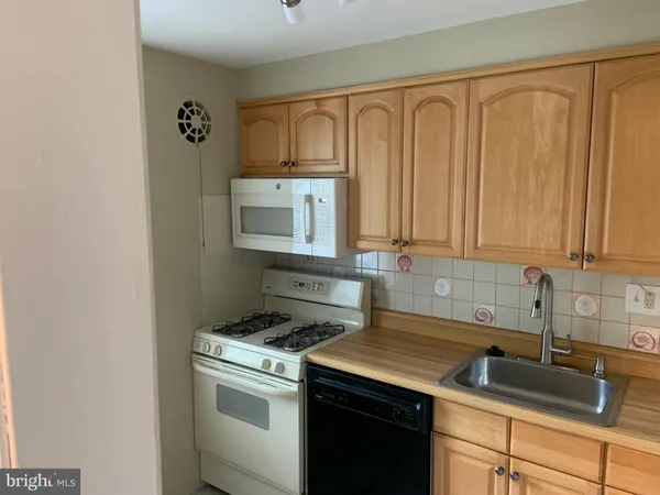 a kitchen with stainless steel appliances granite countertop white cabinets a sink and dishwasher
