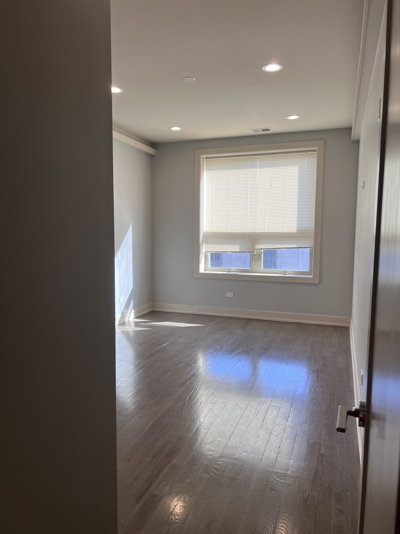 1208 East 64th Street, Unit 3D Chicago, IL 60637 - Photo 12 of 20 an empty room with wooden floor and windows