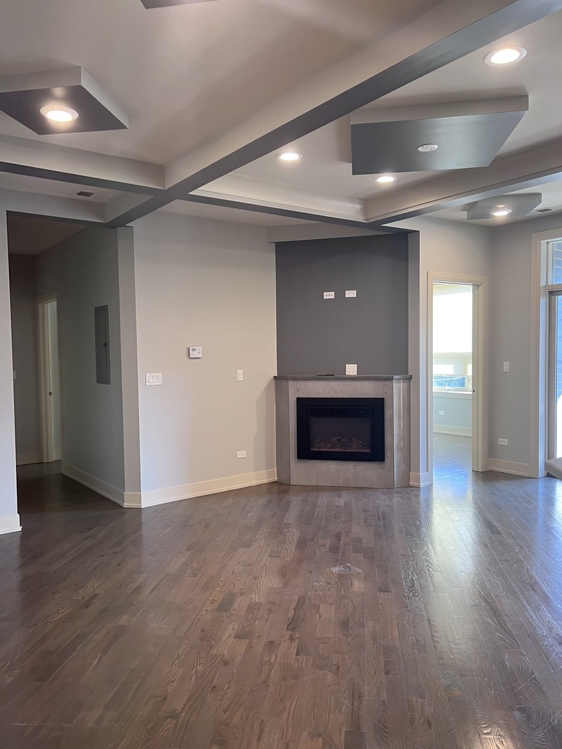 1208 East 64th Street, Unit 3D Chicago, IL 60637 - Photo 7 of 20 an empty room with wooden floor and windows