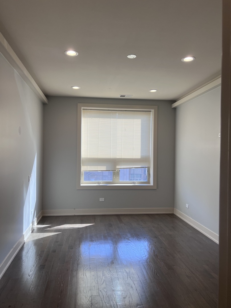 1208 East 64th Street, Unit 3D Chicago, IL 60637 - Photo 9 of 20 an empty room with wooden floor and windows