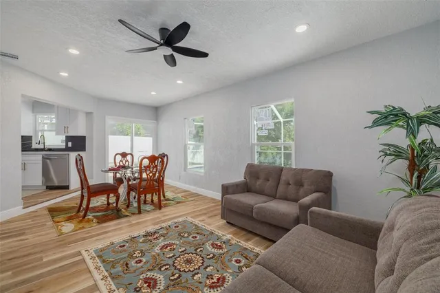 a living room with furniture and a dining table with kitchen view