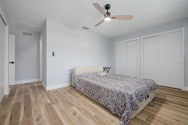 a bedroom with a bed and wooden floor