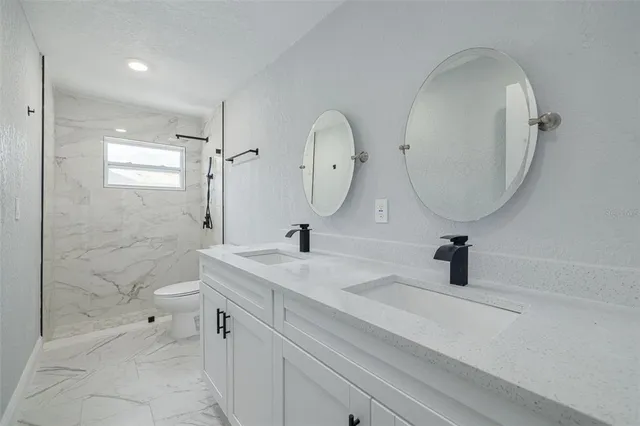 a bathroom with a sink a toilet and a mirror