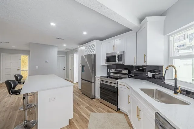 a kitchen that has a sink cabinets counter space and stainless steel appliances