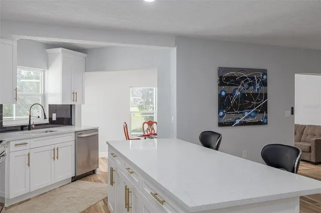 a kitchen with a sink a stove and white cabinets