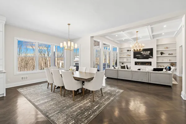 a living room with furniture a flat screen tv and a chandelier