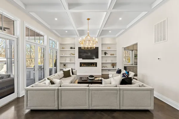 a living room with furniture chandelier and a large window