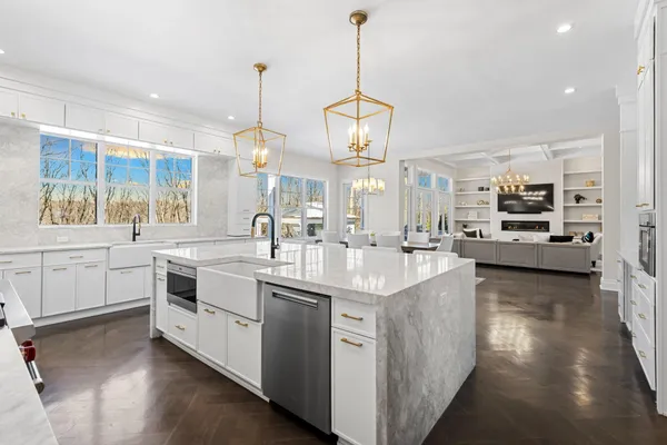 a kitchen with stainless steel appliances granite countertop a sink a stove and a wooden floors